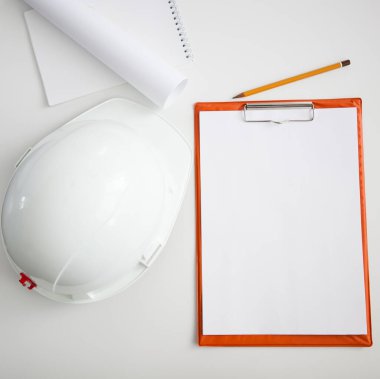 Beyaz arka plan, not defteri ve kalem üzerinde beyaz bir miğfer