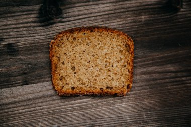 Koyu arkaplanda taze pişmiş siyah çavdar ekmeği. Beleş metin alanı olan kasvetli bir arkaplan. en üstteki görünüm