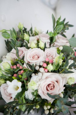 Boho 'da düğün buketi, köy usulü. Yumuşak pembe güller, Eustomalar ve okaliptüs dalları.