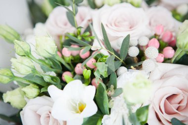 Boho 'da düğün buketi, köy usulü. Yumuşak pembe güller, Eustomalar ve okaliptüs dalları.