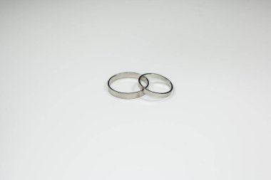 Beyaz arka planda beyaz metalden yapılmış klasik alyanslar.