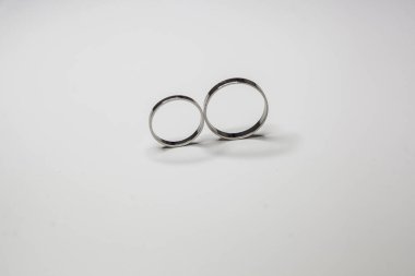 Beyaz arka planda beyaz metalden yapılmış klasik alyanslar.