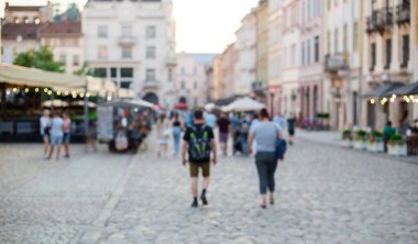 Yürüyen caddenin bulanık arka planı kalabalıkla dolu. İnsanlar eski kasabada güneşli bir günün tadını çıkarıyorlar. Dekoratif reklamlar için arka plan..