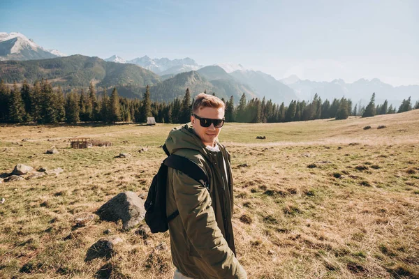 선글라스를 쓴 젊은이 가 산꼭대기의 풍경을 본다. 자유, 행복, 여행 및 휴가 개념, 옥외 활동 — 스톡 사진