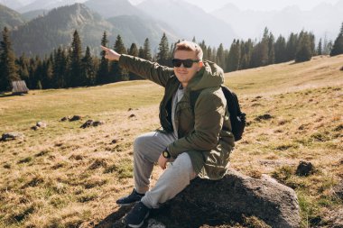 Adam işaret ediyor. Özgürlük, mutluluk, seyahat ve tatil konsepti, açık hava aktiviteleri. Sonbaharda yürüyüş patikaları. Güzel Manzara Manzarası. Avrupa Doğa.