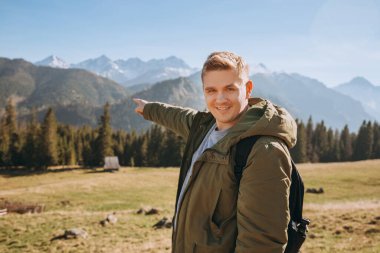 Adam işaret ediyor. Özgürlük, mutluluk, seyahat ve tatil konsepti, açık hava aktiviteleri. Sonbaharda yürüyüş patikaları. Güzel Manzara Manzarası. Avrupa Doğa.