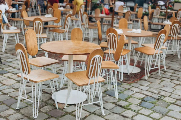 Κενές καρέκλες σε υπαίθριο καφέ ή εστιατόριο την καλοκαιρινή μέρα. Τραπεζάκια που περιμένουν τους πελάτες, παλιά πόλη — Φωτογραφία Αρχείου