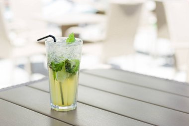 Bir bardak limonata ya da naneli mojito kokteyli, serin, ferahlatıcı içecek ya da içecek, açık havada. Buzlu ve samanlı soğuk detoks suyu, boşluğu kopyala.