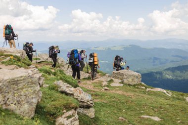 08.07.2021 Ukrayna, Karpatlar - Sırt çantalı bir grup yürüyüşçü dağlarda yürüyor
