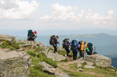 08.07.2021 Ukrayna, Karpatlar - Sırt çantalı bir grup yürüyüşçü dağlarda yürüyor. Özgürlük, seyahat kavramı