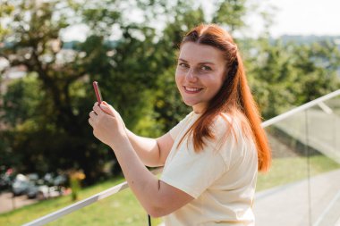 Çantası olan pozitif neşeli bir kızın portresi sosyal medyayı paylaşıyor, sosyal medyayı paylaşıyor, yaz zamanı. teknoloji kavramı