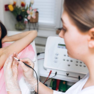 Bir kadının koltuk altlarında metod elektro epilasyon kullanarak kılların kalıcı olarak alınması prosedürü. İstenmeyen kılların kalıcı olarak alınması. Elektroliz iğnesi. Kozmetik tıp dolabındaki doktor..