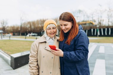 Kadınlar açık havada ne ile ilgilendiklerini öğrenmek için akıllı telefon kullanırlar. İnternet, ağ kurma konsepti hakkında bilgi aranıyor. Akıllı telefondan video izleyen arkadaşlar