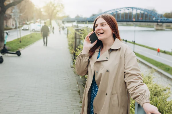Beautiful smiling female talking on Phone outdoors. Phone Communication. Happy cheerful young woman walking on city street, Urban lifestyle concept. Traveler — Stock fotografie