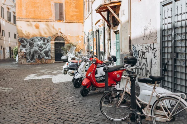 Rome, Italy April 4, 2022 - Cozy old street in Trastevere in Rome, Italy. Architecture and landmarks of Rome. Bright many scooters are parked on the city street — Fotografia de Stock
