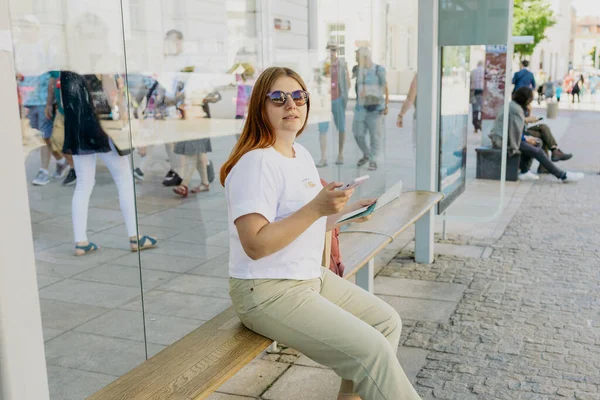 Una Alegre Mujer Caucásica Está Sentada Banco Dentro Una Parada — Foto de Stock
