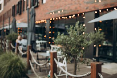 Blurred background of outdoor restaurant with abstract bokeh light.