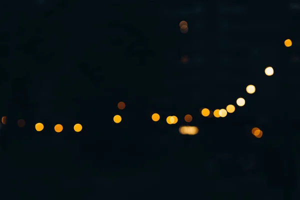 Decorative outdoor string lights at night time, Defocused Background, night city life backdrop, party time with bokeh balls