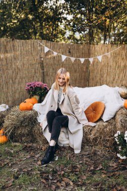 Doğada giyinmiş şık bir kadın. Sonbahar sezonunda açık havada zarafet. Moda kadın kıyafetleri, sonbahar moda koleksiyonu..