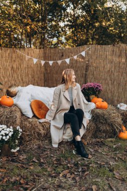 Doğada giyinmiş şık bir kadın. Sonbahar sezonunda açık havada zarafet. Moda kadın kıyafetleri, sonbahar moda koleksiyonu..