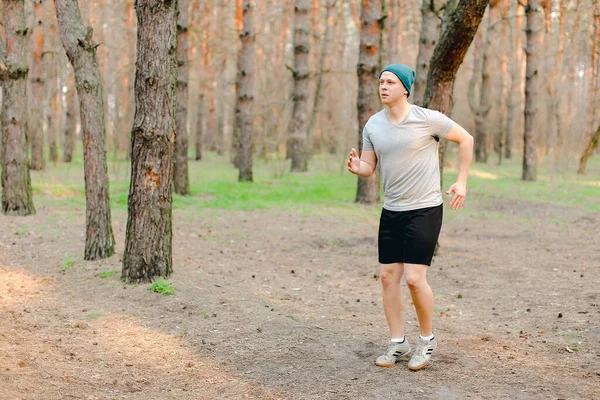 Młody człowiek jogging i bieganie w parku rano na świeżym powietrzu. — Zdjęcie stockowe