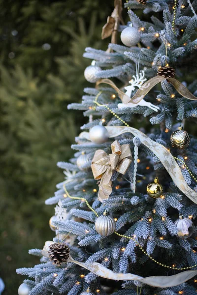 Close-up van kerstboom met decoratieve ballen en bloemenslingers erop — Stockfoto