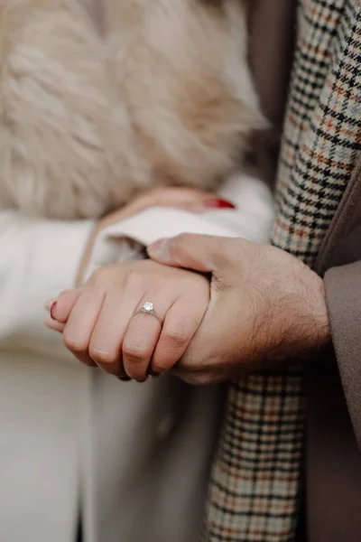 Casal noivo de mãos dadas de perto, apenas proposto com anel de diamante — Fotografia de Stock