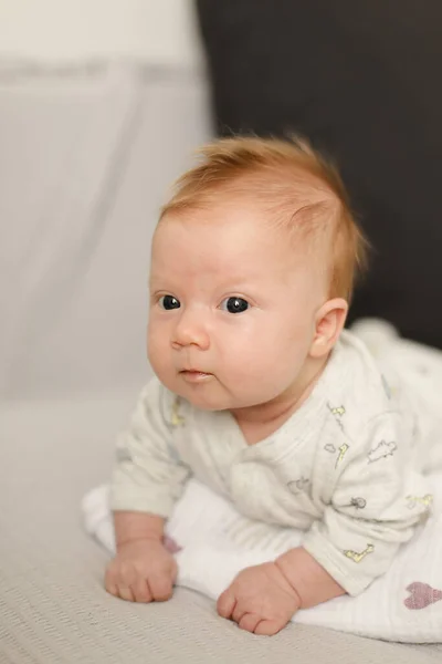 白いベッドスプレッドに横たわるかなり新生児の肖像画. — ストック写真