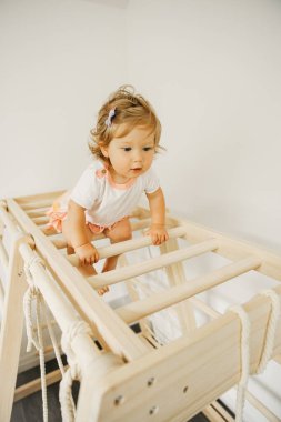 Bebek evde, anaokulunda ya da kreşte gelişmekte olan ahşap yapılarla oynuyor.