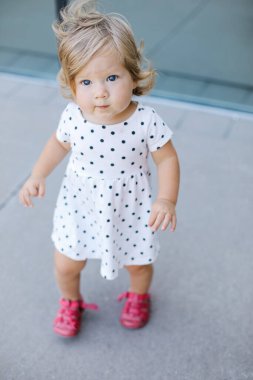 Sevimli bir kız bebek kameraya bakıyor. Dikey çekim.