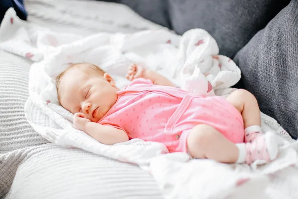 Menina recém-nascida dormir em cobertor branco e vestindo roupas rosa. — Fotografia de Stock