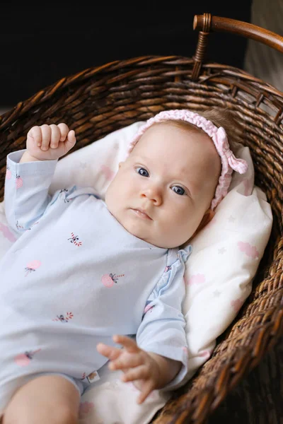 Cute little american baby lying in wicker basket on floor. — Stock Photo, Image