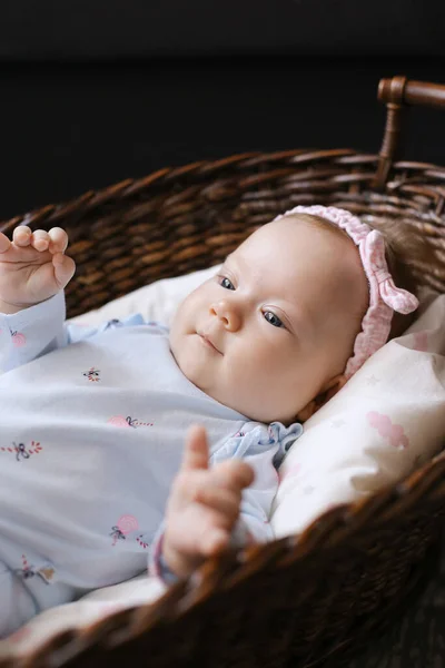 Close up little baby lying in wicker basket on floor. — Stock Photo, Image