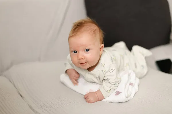 Portrait of newborn baby lying on white bedspread. — Stock Photo, Image