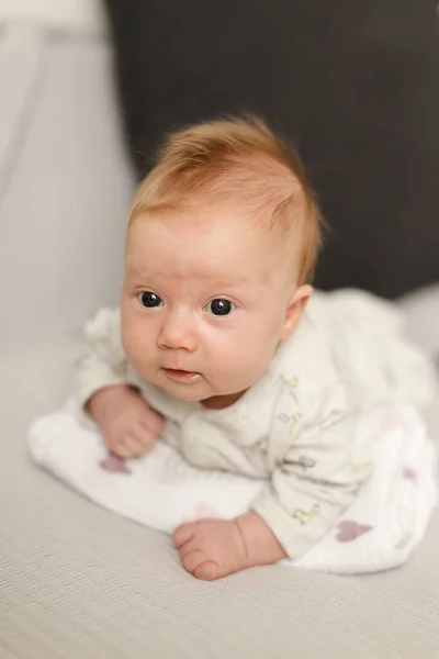 Portrait of cute newborn baby lying on white bedspread. — Stock Photo, Image