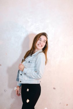 Kamera, ışık duvar arka plan üzerinde ayakta poz gülümseme ile güzel kadın.