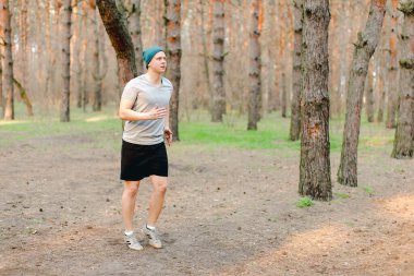 Genç adam sabah parkında koşuyor..