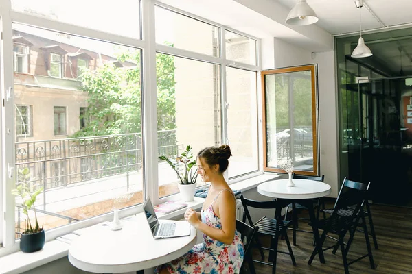 Jong amerikaans meisje zitten met laptop in cafe. — Stockfoto