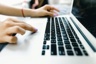 Laptop klavyesinde yazı yazan küçük tırnaklı yakın eller.