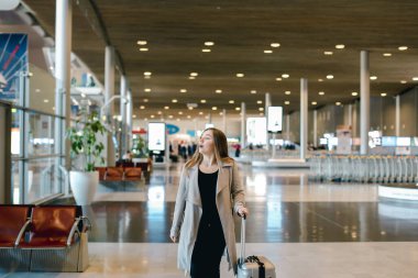 Havaalanı salonunda yürüyüş gri ceket giyen kadın kişi.