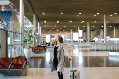 Avrupa kadın kişi Havaalanı salonunda yürüyüş gri bir palto giyiyor