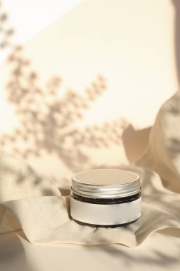 Nötr ışık arka planında izole edilmiş kremalı ve kapaklı plastik kavanoz. Güzellik merkezi ve cilt ürünleriyle ilgilenmek.