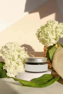 Nötr ışık arka planında izole edilmiş kremalı ve kapaklı plastik kavanoz. Güzellik merkezi ve cilt ürünleriyle ilgilenmek.