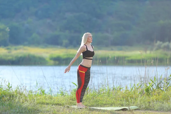 Jovem bela mulher agachamentos mostra resultado pressione no treino de estômago vestindo top — Fotografia de Stock