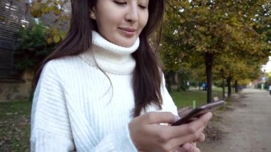Slow Motion Kapan Asyalı genç bir kadın şehirde telefon kullanıyor güzel bir Çinli kız cep telefonunda yazıyor Chengdu China 'da bir şehir akşamı