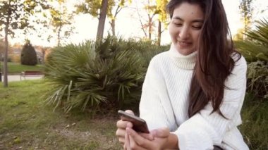 Slow Motion genç ve güzel kız akıllı telefon kullanıyor.