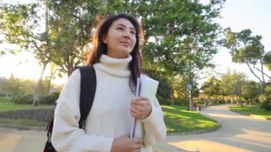 Gözlüklü neşeli bayan turist modern telefon cihazına navigatör takıyor şehir ortamında sokaklarda yürüyor. Olumlu gezgin geziniyor ve web sitesinde yeni bir yazı yayınlıyor.