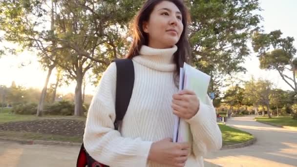 Hidas liike Iloinen naisturisti silmälaseissa asentamassa navigaattoria nykyaikaiseen puhelinlaitteeseen kävellen kaduilla kaupunkiympäristössä.positiivinen matkustaja kävelemässä ja julkaisemassa uutta viestiä verkkosivustolla — kuvapankkivideo