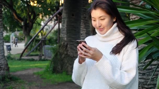 Retrato en cámara lenta de una mujer que envía mensajes de texto desde su teléfono — Vídeos de Stock