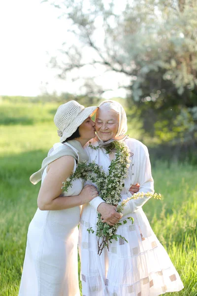 Retrato de filha caucasiana beijando mãe velha fora. — Fotografia de Stock